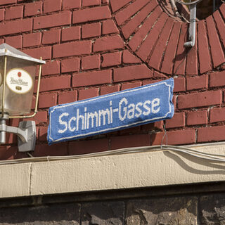 getricktes Namensschild der Horst Schimanski Gasse in Duisburg-Ruhrort
