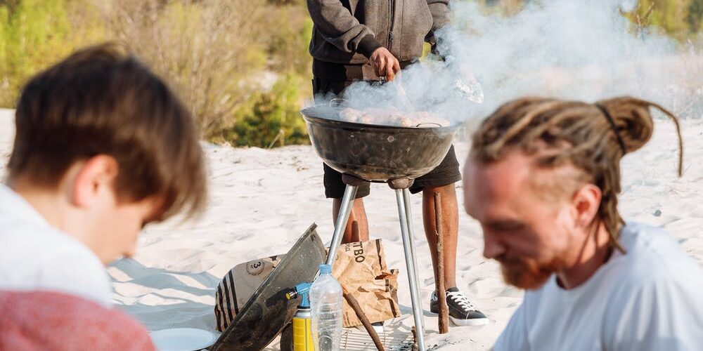 Drei Freunde grillen in den Dünen