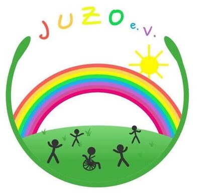 rundes Logo (Strichmännchen (eines im Rollstuhl) auf der Wiese unter einem Regenbogen, dazu eine Sonne