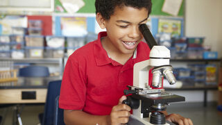 Junge am Mikroskop
