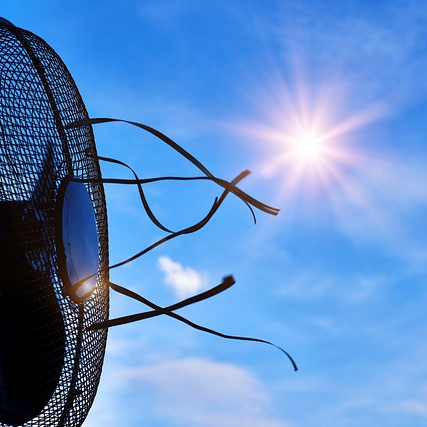 Ein Ventilator vor blauem Himmel mit viel Sonnenscheid