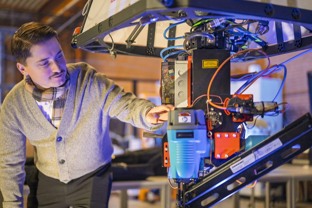 Doktorand Christoph Jeziorek zeigt die Aufhängung, an der unterschiedliche Werkzeuge montiert werden können