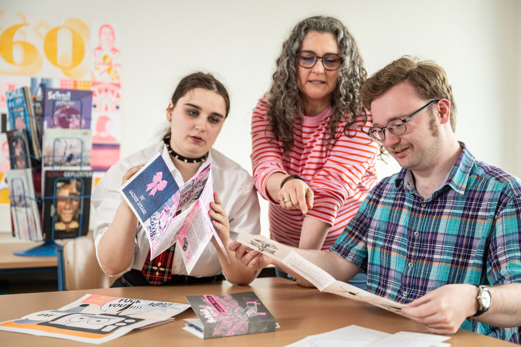 Die Risographie-Ausgabe wurde aufwändig händisch gefaltet: Charline Wolsbeck (v.li.), Lehrerin Julia Doppelfeld und Simon Cilleßen haben viele Stunden damit verbracht.