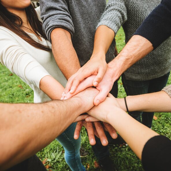 Leute halten ihre Hände zusammen und übereinander