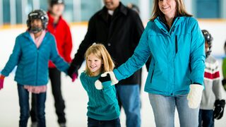 Frau und Kind fahren Schlittschuh