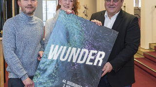 Mit dem Plakat der Akzente sind zu sehen (v. l.) Clemens Richert, Petra Schröder, beide Kulturbetriebe, und Kulturdezernent Matthias Börger.