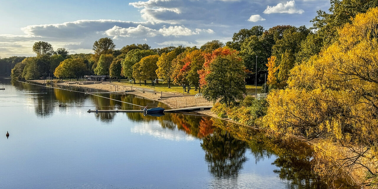 Strandbad Wolfssee im Herbst mit bunten Laubbäumen