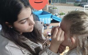 Frau und Kind beim Kinderschminken