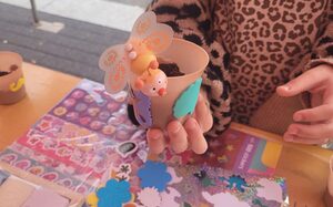 Hand mit Blumentopf und Bastelutensilien
