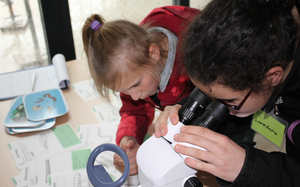 Schülerinnen vor einem Mikroskop