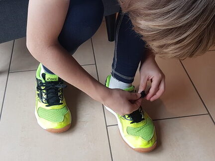 Kind bindet eine Schleife