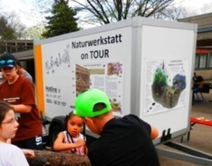 Kinder vor dem Anhänger der Naturwerkstatt