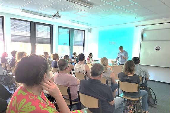 Antje Bostelmann und Silke Schaper im WS und Teilnehmende am Infostand