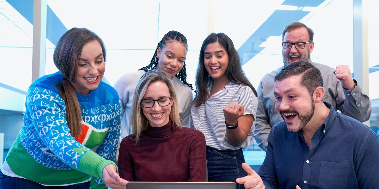 Eine Gruppe von Menschen rund um einen Laptop