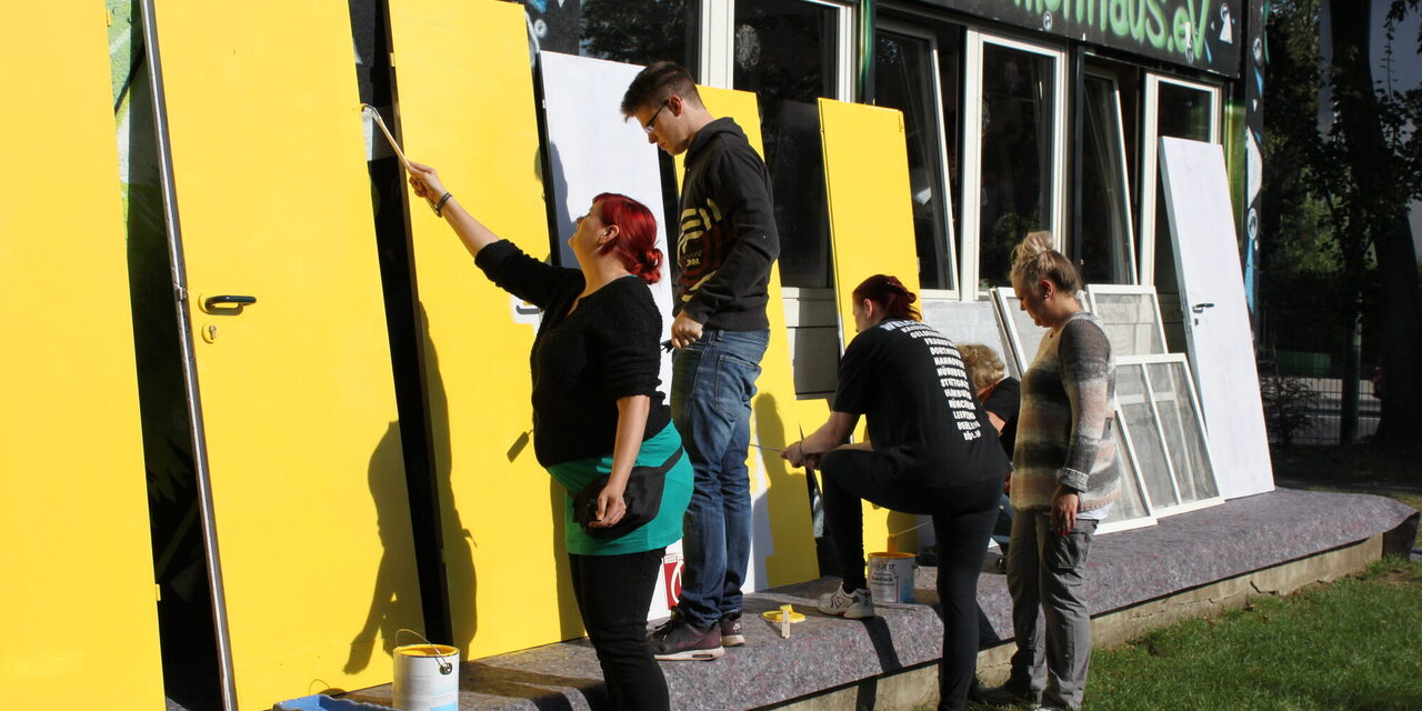 Menschen streichen Türen an.