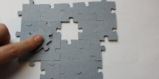Eine Hand legt ein Puzzle