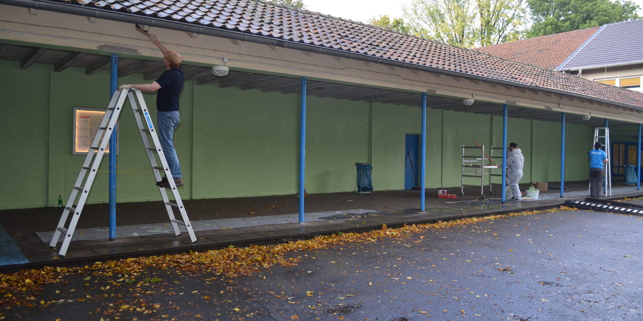 Mitarbeiter streichen den Laubengang