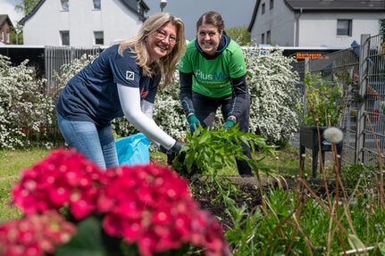 Zwei Mitarbeiterinnen der Deutschen Bank setzen neue Pflanzen ein