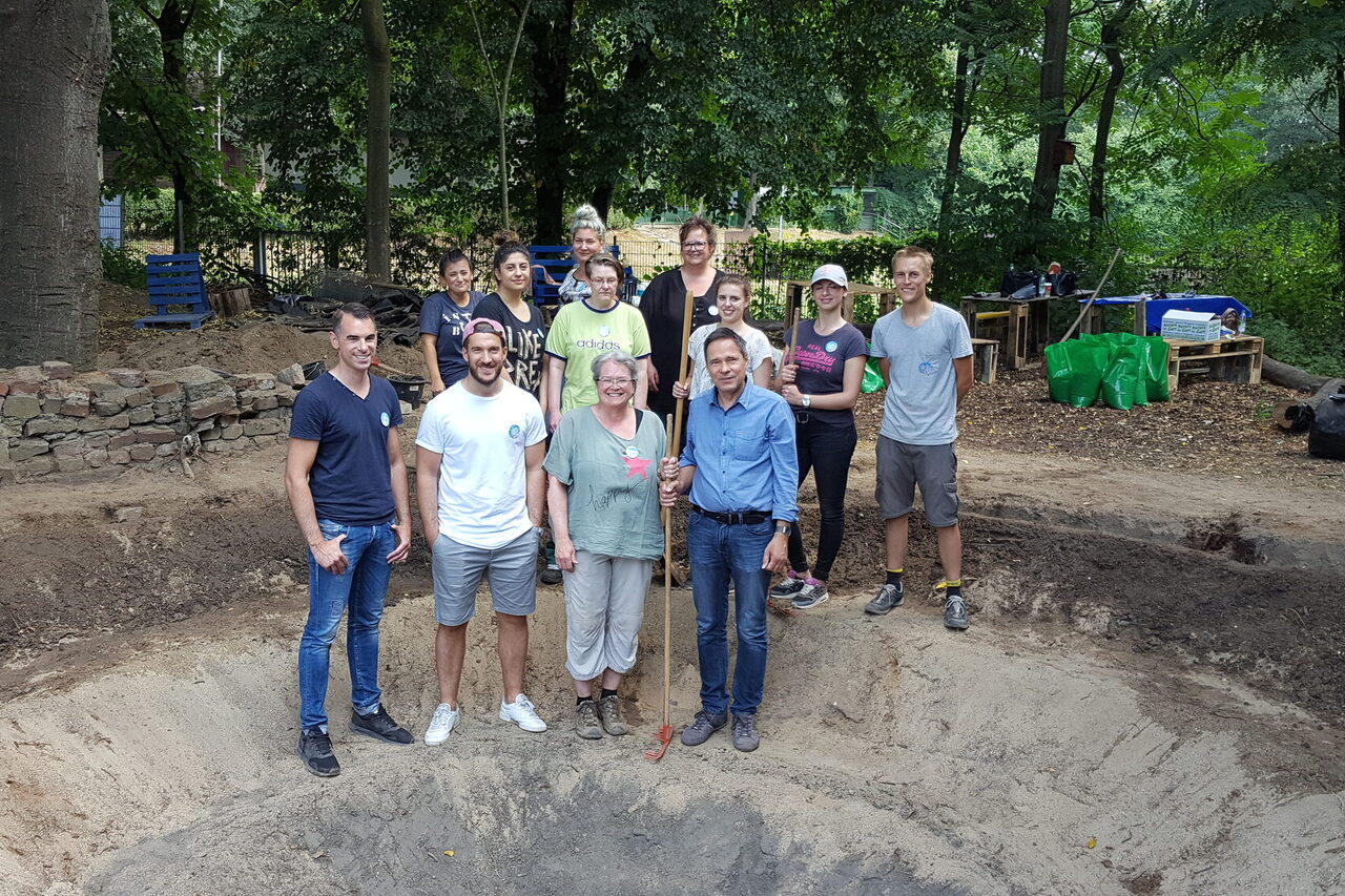 Eine Gruppe steht in einem Teichbecken.