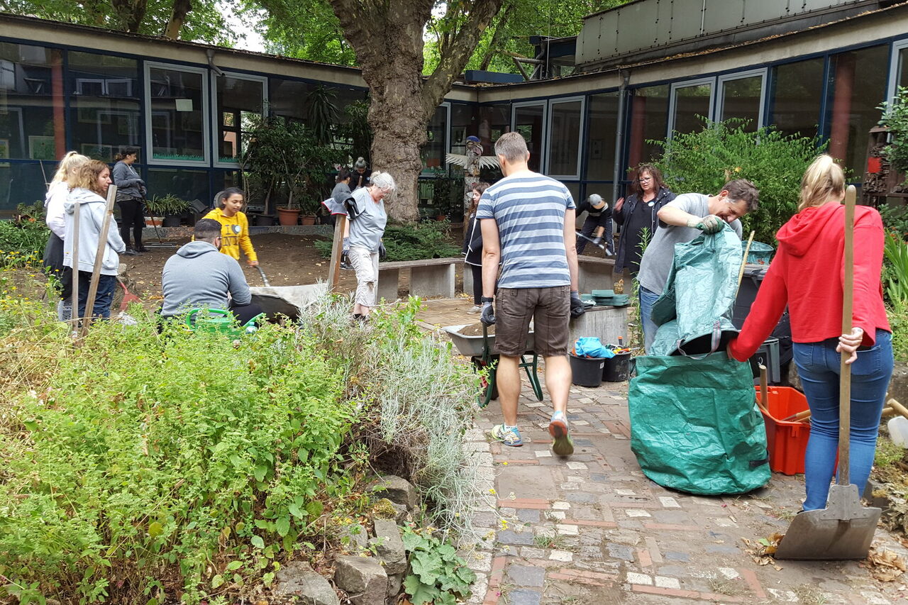 Menschen arbeiten in einem Schulgarten