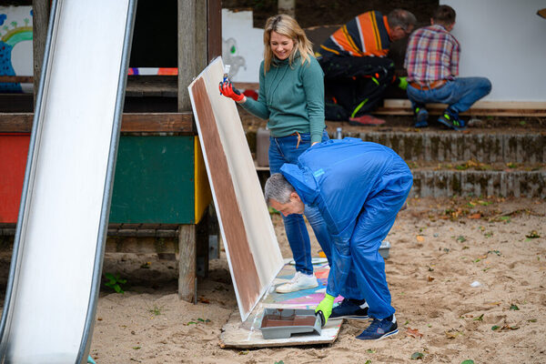 Eine Frau und ein Mann bemalen Paletten.