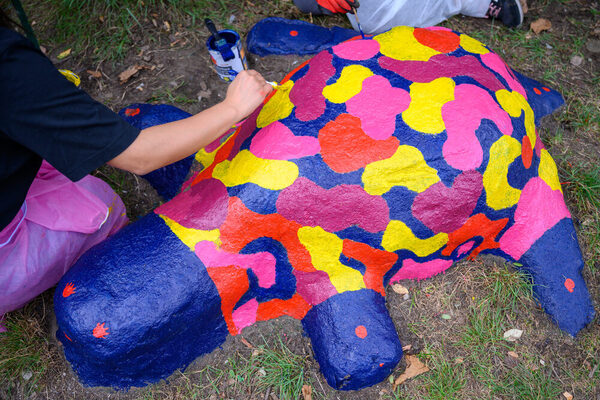 Zwei Männer bauen mit Holzpaletten eine Sitzbank.