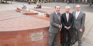 Paten vor dem Brunnen und der Sparkasse