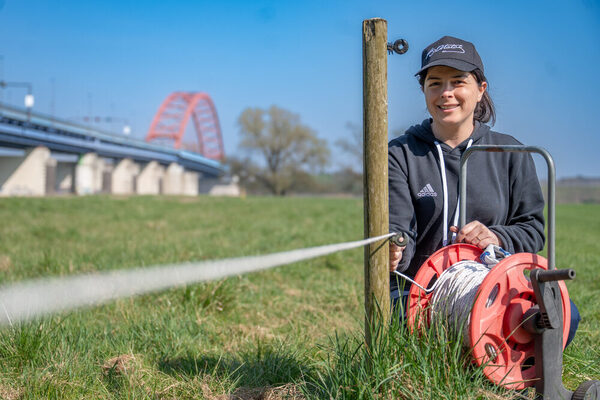 Auszubildende spannt einen neuen Zaun