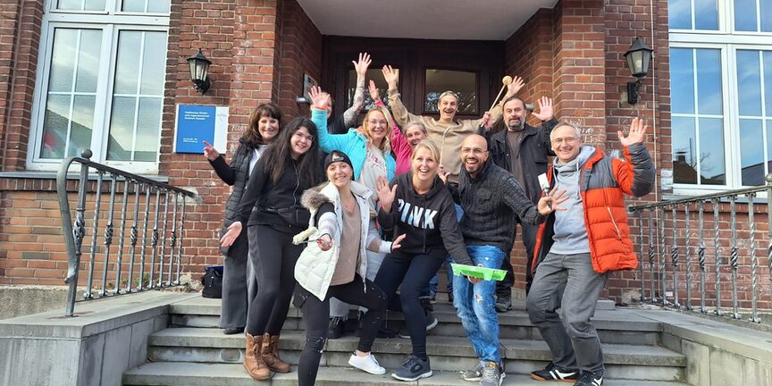 Gruppenfoto der Mitarbeiterinnen und Mitarbeiter der Targobank auf den Stufen des Kinder- und Jugendzentrums in Rumeln