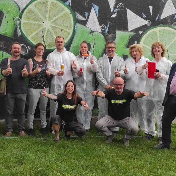 Mitarbeitende von TotalEnergies im Arbeitsdress vor dem Jugendzentrum