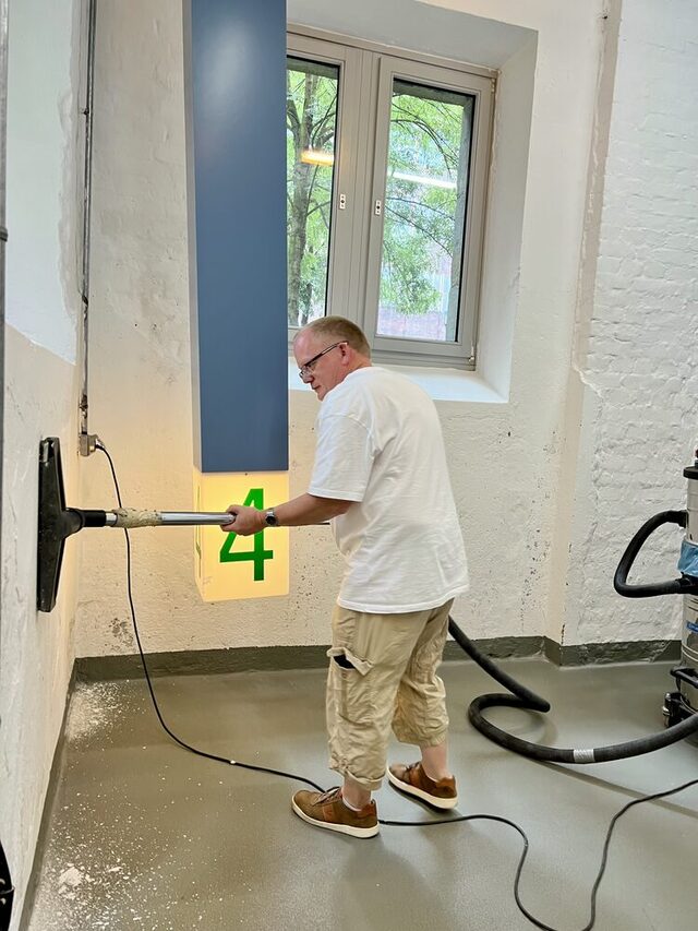 Mitarbeiter beim Absaugen des Staubes