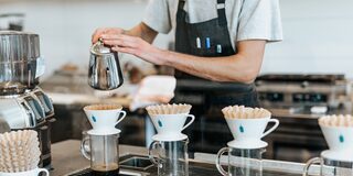 Bild eines Cafés von innen; zu sehen sind Kaffegläser mit Filtertüten