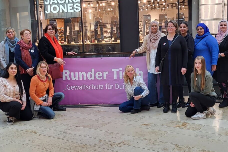Das Orga-Team mit bRatsfrau Stecker und der Elisabeth Koal vor dem neuen Banner des Runden Tisches "Gewaltschutz für Duisburg" im FORUM Duisburg