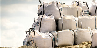 Mit Sand gefüllte BigBags die zu einem Notdeich aufgestapelt sind