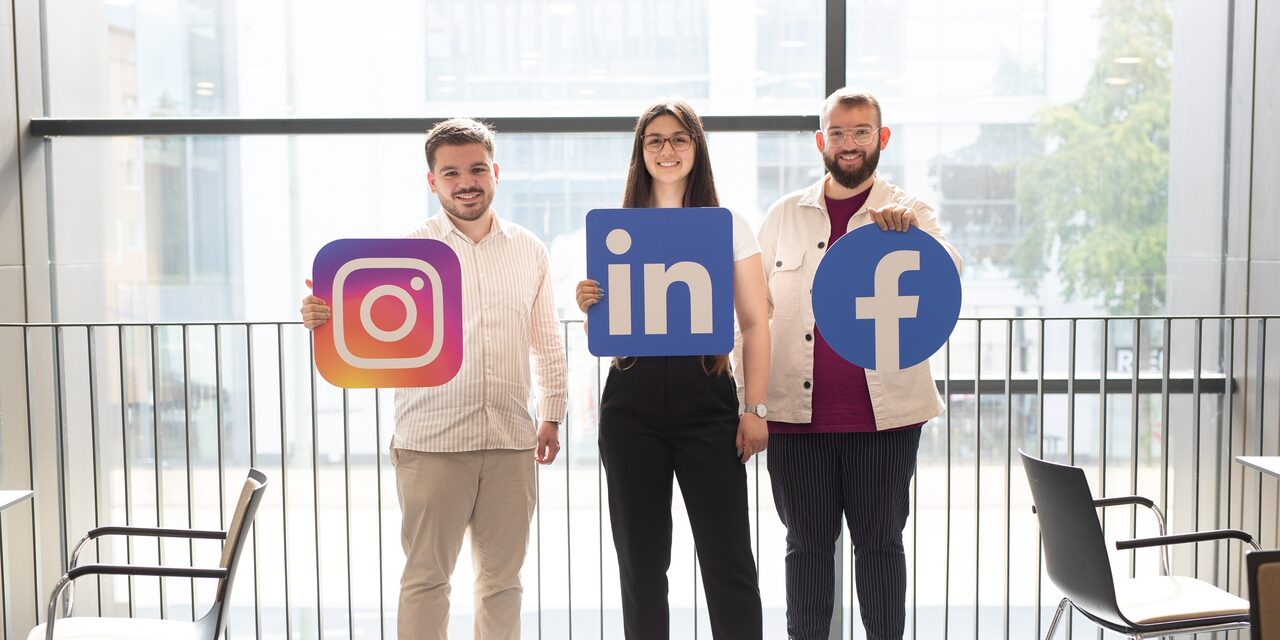 Junge Menschen halten Piktogramme social media hoch