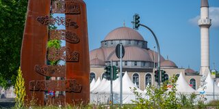 Dialogskulptur von Denizli Yildirim, im Hintergrund ist die Marxloher Moschee zu sehen