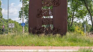 Die Dialogskulptur in ihrer neuen Umgebung, umgeben von Rasen und Grün.