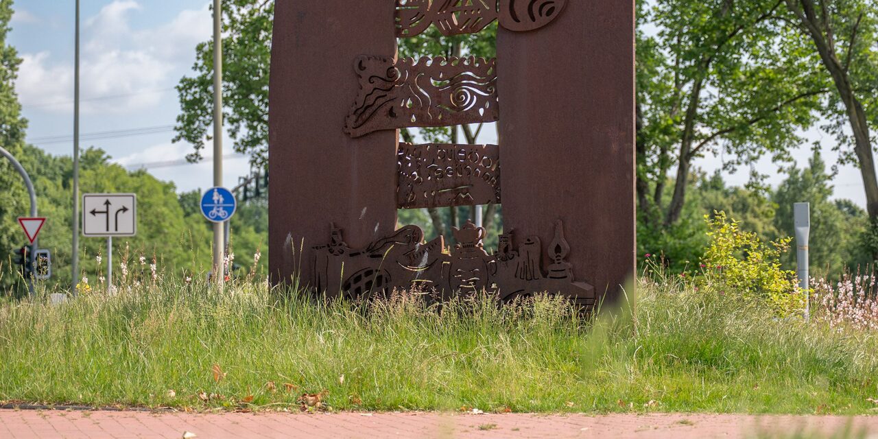 Die Dialogskulptur in ihrer neuen Umgebung, umgeben von Rasen und Grün.