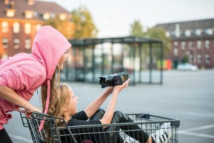 Mädchen drehen Video im Einkaufswagen