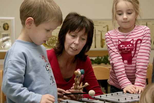 Lehrerin mit Junge und Mädchen am Xylophon