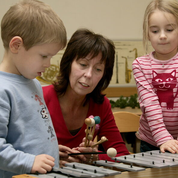 Lehrerin mit Junge und Mädchen am Xylophon
