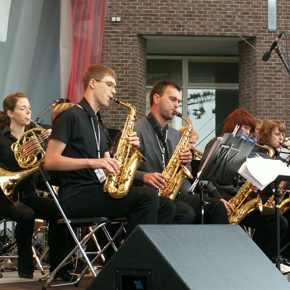 BigBand auf Stühlen mit Saxophonen und Horn