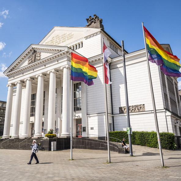 Stadtflagge und Regenbogenflaggen wehen vor dem Stadttheater Duisburg