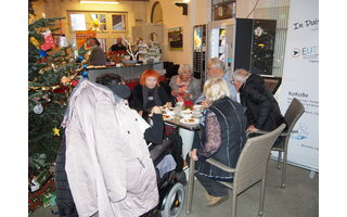 Mehrere Teilnehmer*innen sitzen an einem Tisch und essen