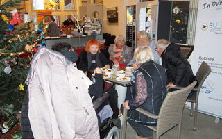 Mehrere Teilnehmer*innen sitzen an einem Tisch und essen