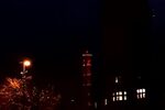 Der Stadtwerketurm leuchtet orange in der Dunkelheit, rechts daneben das Rathaus