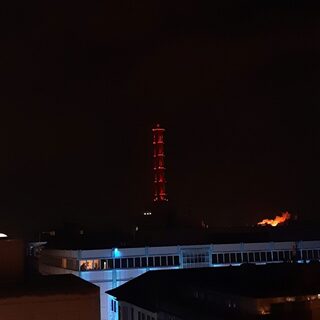Der Stadtwerketurm leuchtet orange in der Dunkelheit