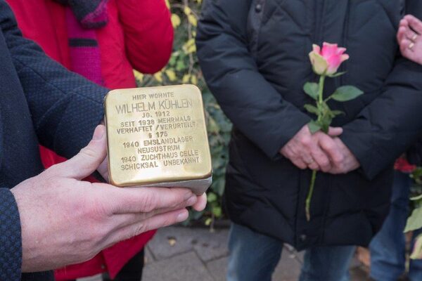 Oberbürgermeister Link hält den Stolperstein in die Kamera