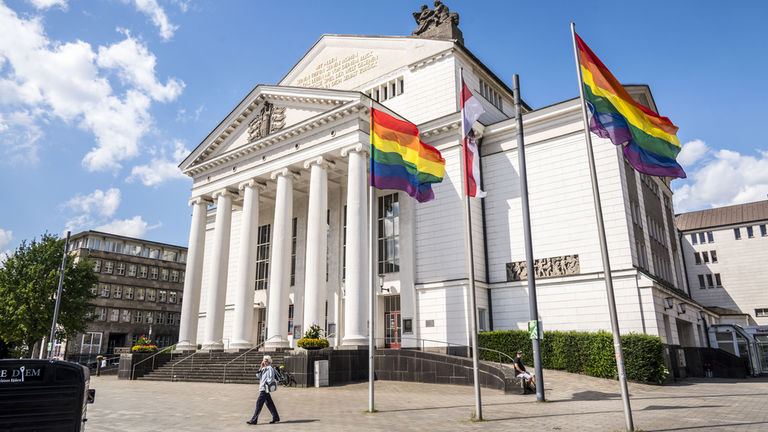 Stadtflagge und Regenbogenflaggen wehen vor dem Stadttheater Duisburg