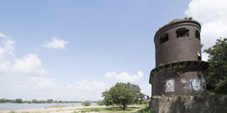 Beeckerwerth - Der sogenannte Mäuseturm am Rhein bei Beeckerwerth. Der ehemalige Schiffsmeldeturm am Rhein versteckt sich hinter Bäumen.